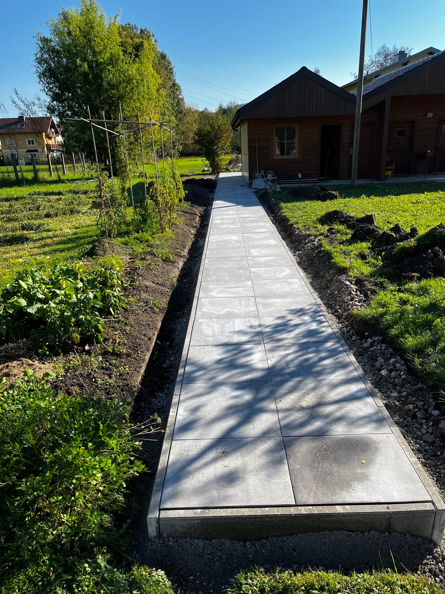 Plattenweg durch einen Gemüsegarten