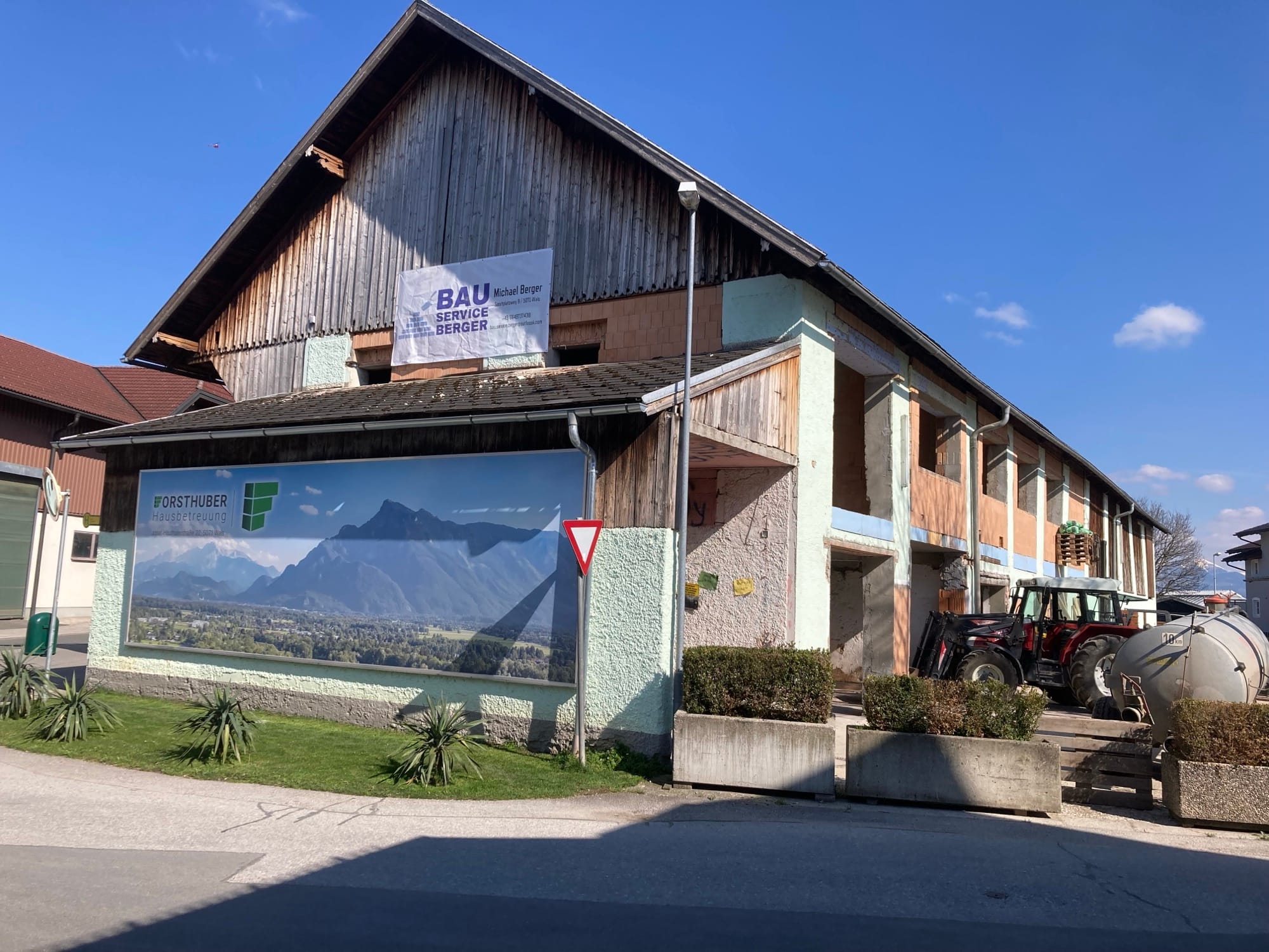 Sanierter Wirtschaftstrakt mit Banner von Bauservice Berger